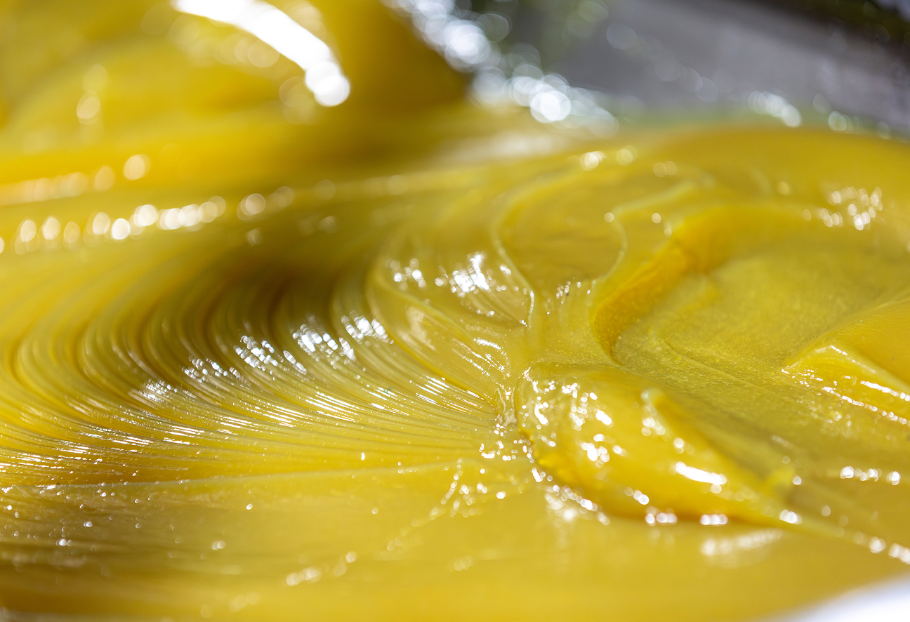 Close-up of shiny, yellow lubricant with swirling texture.