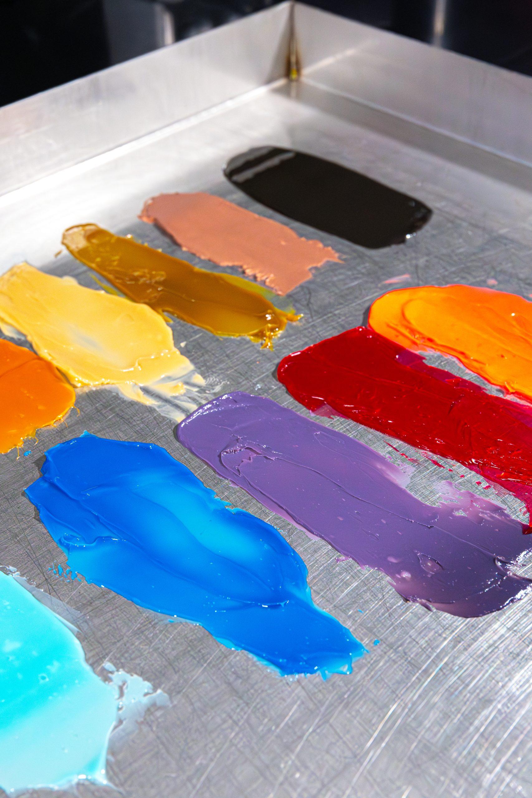 Colorful lubricant smears on a metal surface, showcasing various shades and textures.