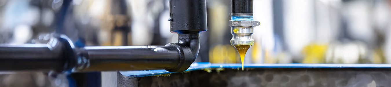 Black pipe dispensing lubricant, showcasing oil flow.