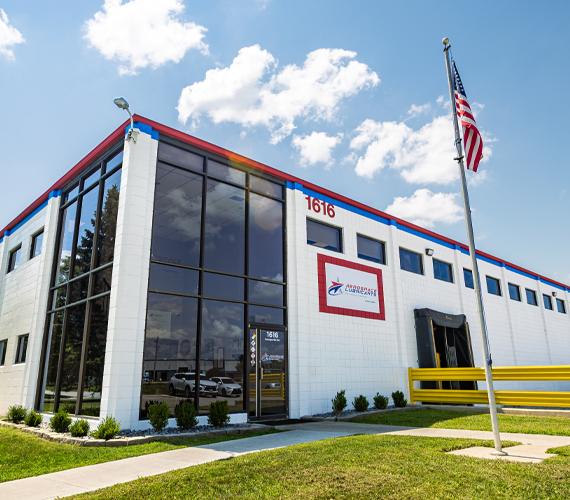 Aerospace Lubricants building with large glass windows, "1616" on facade, and American flag.