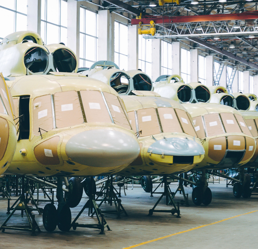 Row of yellow aircraft fuselages in a hangar, emphasizing aerospace manufacturing.